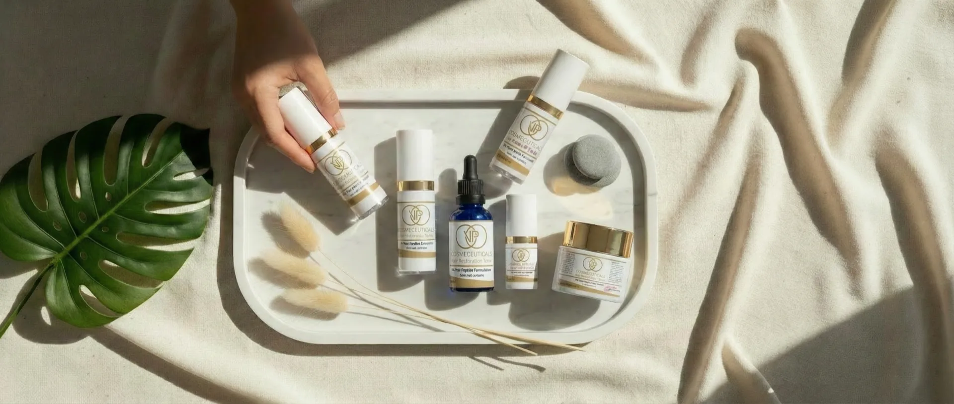The VP Cosmeceuticals peptide skincare collection on a marble tray with botanicals